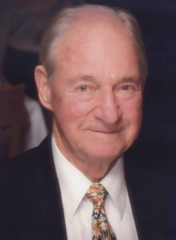 Formal portrait of Frank J. Frost wearing a suit and patterned tie.