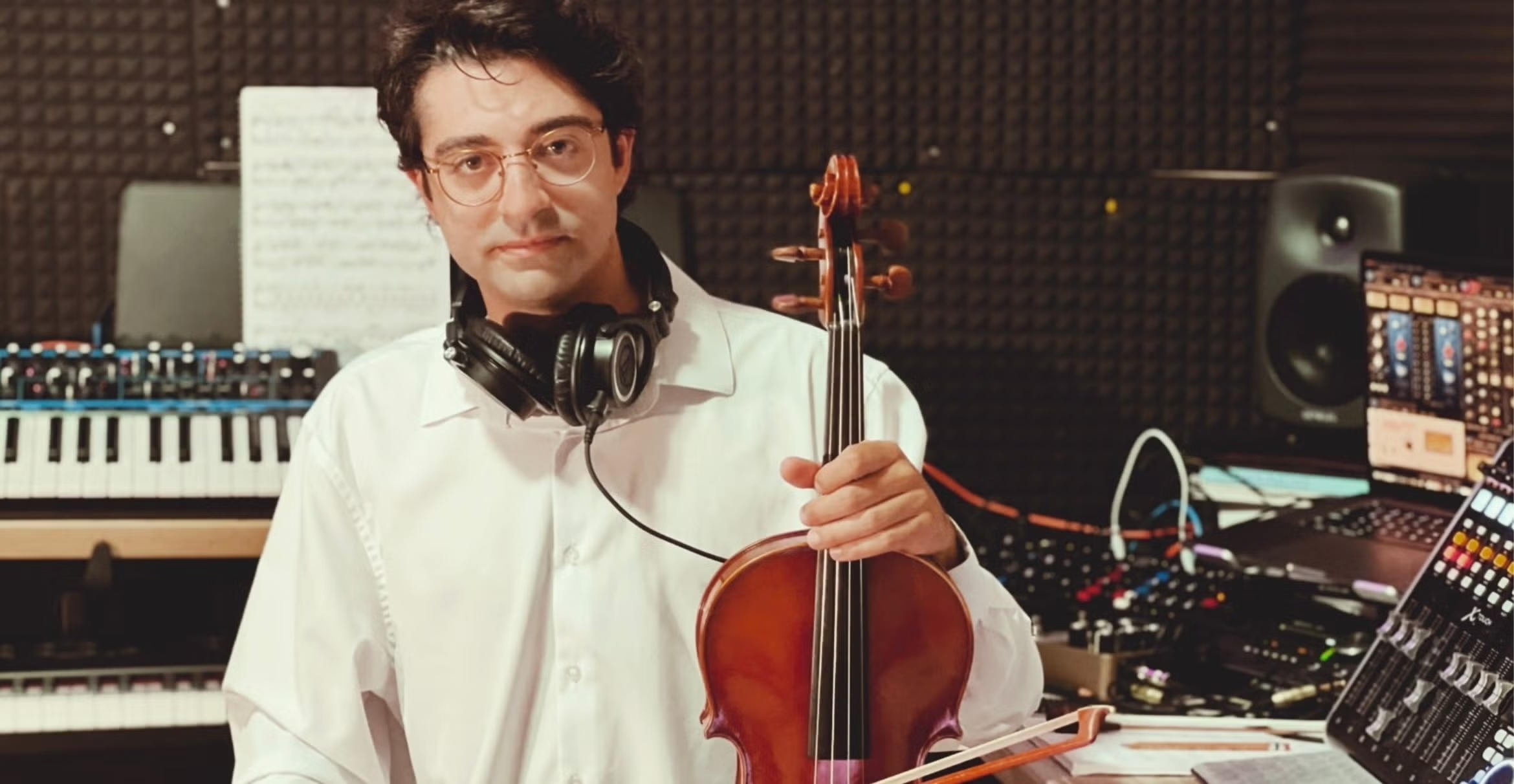 Color photograph of musician Deniz Çağlarcan holding a violin.